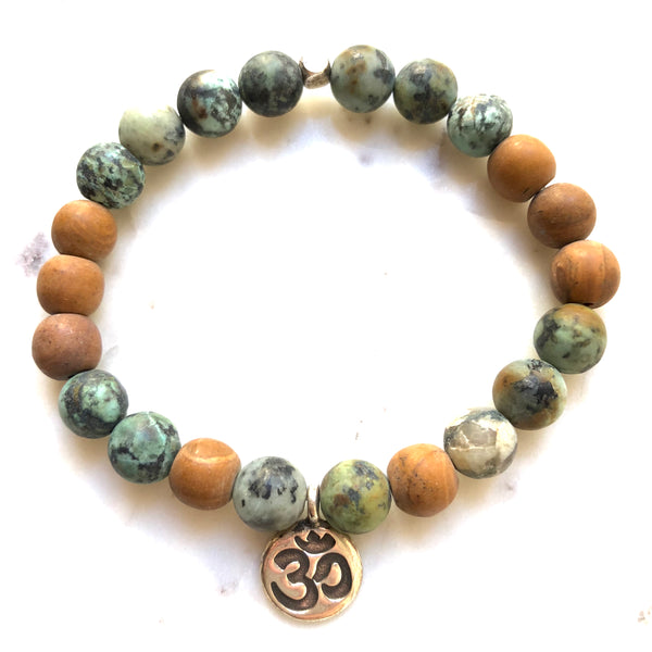 Aria Mala Atelier's unique one-of-a-kind African Turquoise, Natural Sandalwood RA (Eye of Horus) Charm yoga bracelet for spiritual living