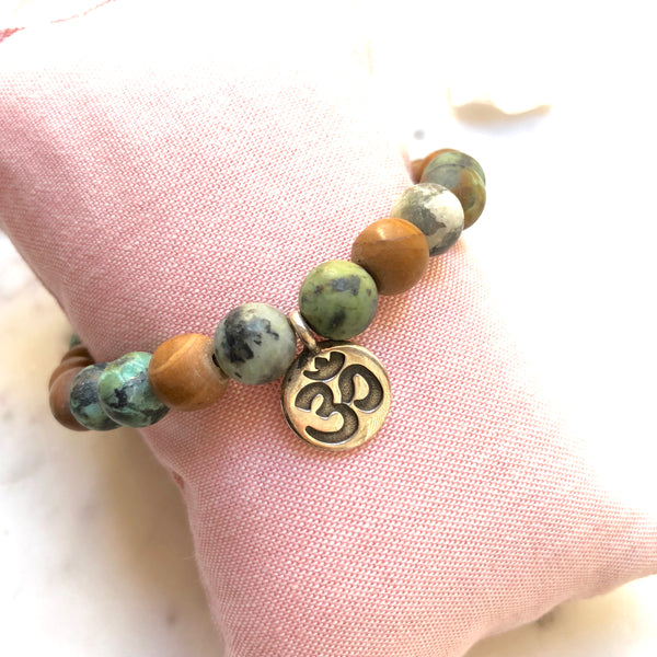Aria Mala Atelier's unique one-of-a-kind African Turquoise, Natural Sandalwood RA (Eye of Horus) Charm yoga bracelet for spiritual living