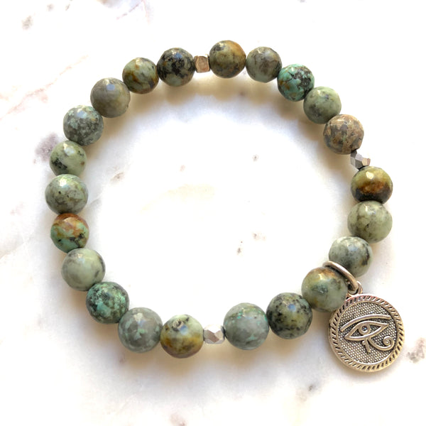 Aria Mala Atelier's unique one-of-a-kind African Turquoise, Natural Sandalwood RA (Eye of Horus) Charm yoga bracelet for spiritual living