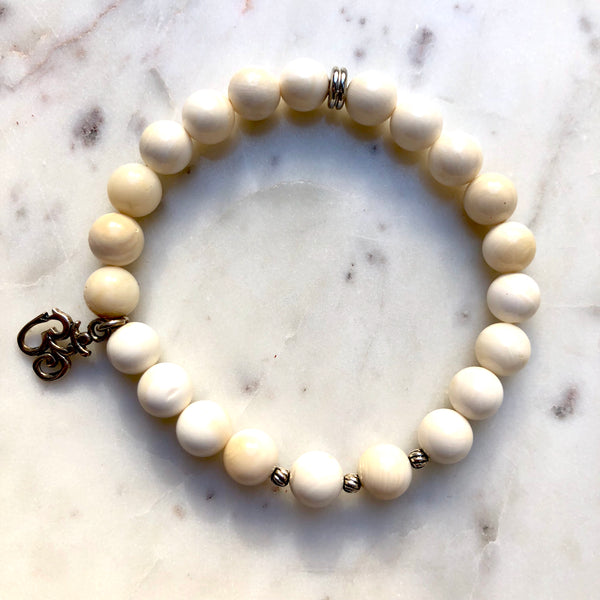 Aria Mala Atelier's unique one-of-a-kind shell stone yoga bracelet with sterling silver OM charm for spiritual living