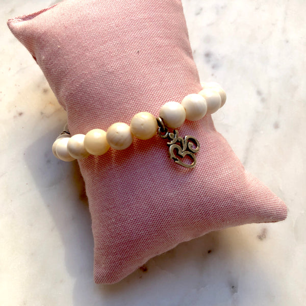 Aria Mala Atelier's unique one-of-a-kind shell stone yoga bracelet with sterling silver OM charm for spiritual living